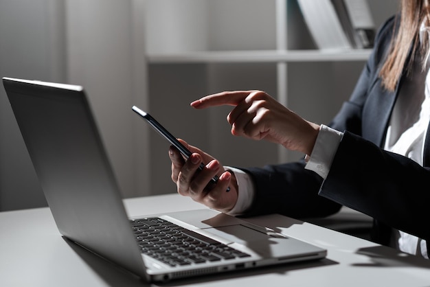 Zakenvrouw Tablet in de ene hand te houden en te wijzen op belangrijk nieuws met één vinger zittende vrouw In kantoor met mobiele telefoon In de hand presenteren van informatie