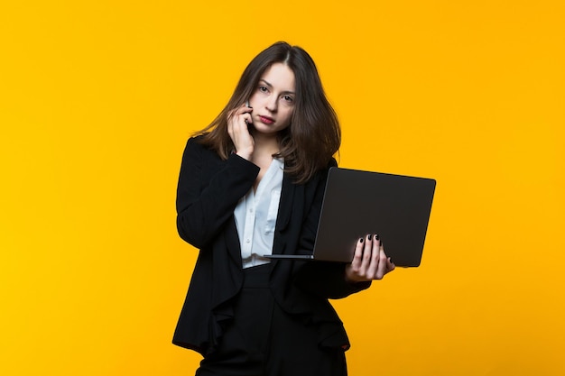 Zakenvrouw, telefoon, gesprek, laptop, gele achtergrond