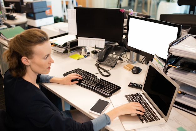 Foto zakenvrouw typen op laptop tijdens het gebruik van desktop-pc