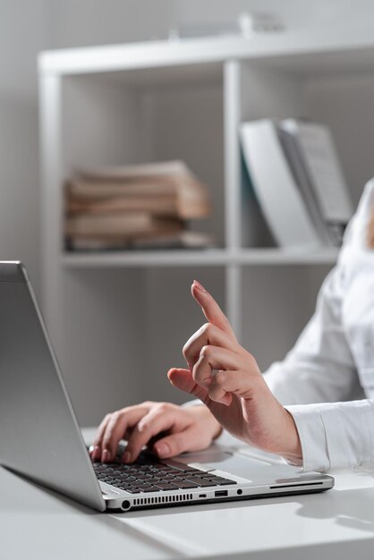 Zakenvrouw typen recente updates op Lap Top toetsenbord op Bureau en wijzen belangrijke ideeën met één vinger Vrouw In Office late berichten schrijven op Computer