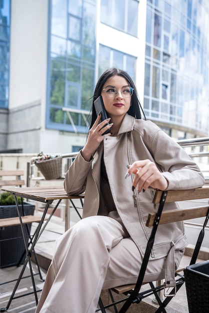 Zakenvrouw wacht op haar partner die aan een tafel zit voor een modern zakencentrum