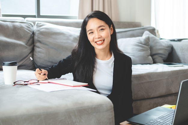 Zakenvrouw werkt met een laptopcomputer vanuit huis, vrouw die werkt met online communicatiezaken en technologie, werkplekbureau met notebook binnen geïsoleerd in een huis