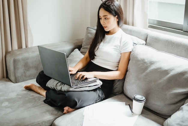 Zakenvrouw werkt met een laptopcomputer vanuit huis, vrouw die werkt met online communicatiezaken en technologie, werkplekbureau met notebook binnen geïsoleerd in een huis