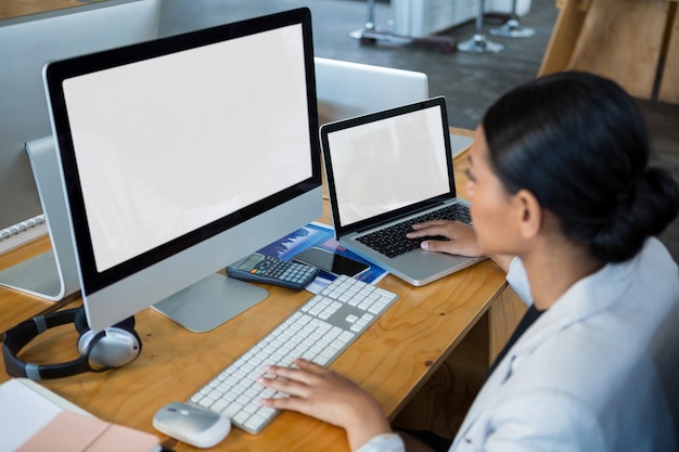 Zakenvrouw werkt via computer en laptop