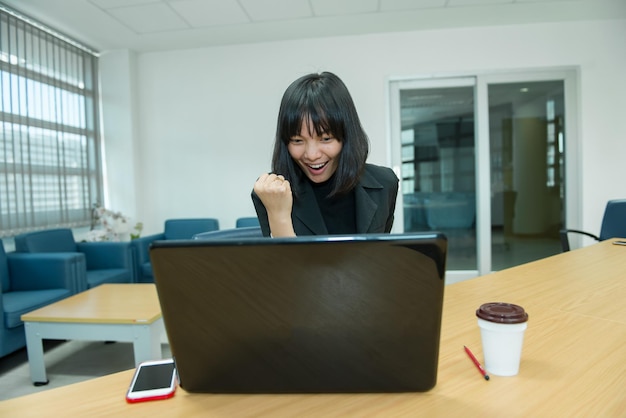 Zakenvrouw wow van laptop Op zoek naar aandelenmarkt Gelukkig Thais vrouwenconceptSecretaris werkt op kantoor