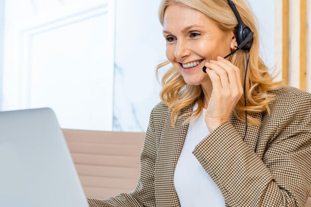 Zakenvrouw zit aan een computerbureau op kantoor en neemt deel aan een videoconferentie