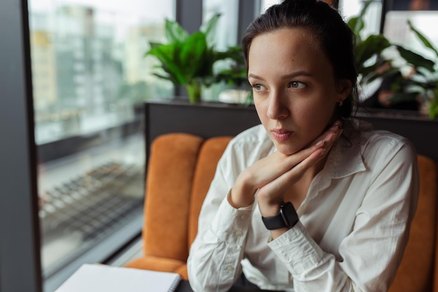 zakenvrouw zit in café en denkt aan project