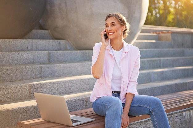 Zakenvrouw zit trap zomer park met behulp van laptop Zakelijke persone werken op afstand Outdoor