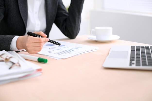 Zakenvrouw zitten aan de tafel en onderzoekt de financiële resultaten.