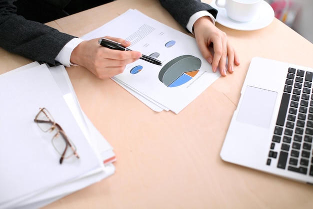 Zakenvrouw zitten aan de tafel en onderzoekt de financiële resultaten.