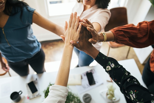 Zakenvrouwen die de handen in het midden zetten