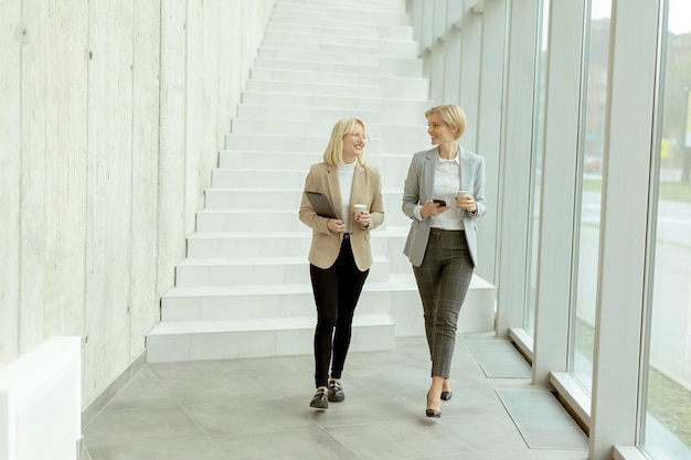 Zakenvrouwen lopen in de kantoorgang