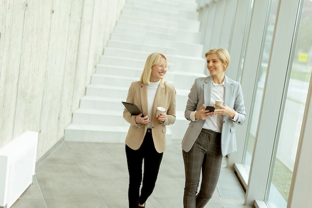 Zakenvrouwen lopen in de kantoorgang