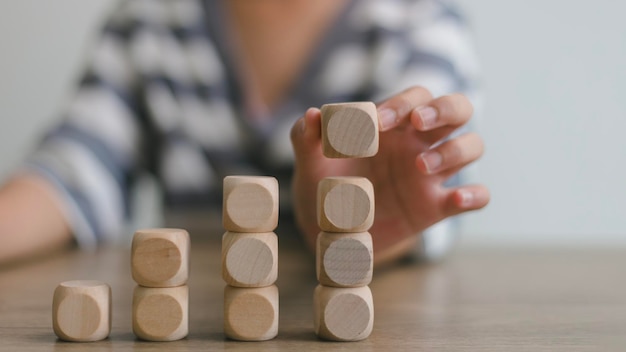 Zakenvrouwen stapelen lege houten kubussen op de tafel met kopieerruimte lege houten cubussen voor het invoeren van woorden en een infografisch icoon