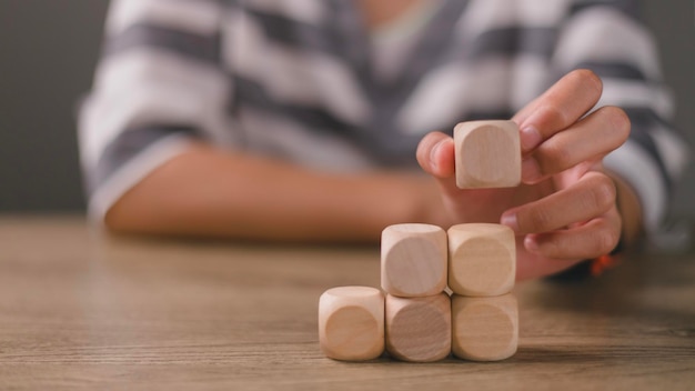 Zakenvrouwen stapelen lege houten kubussen op de tafel met kopieerruimte lege houten kubussen voor invoerwoorden en een infografisch pictogram