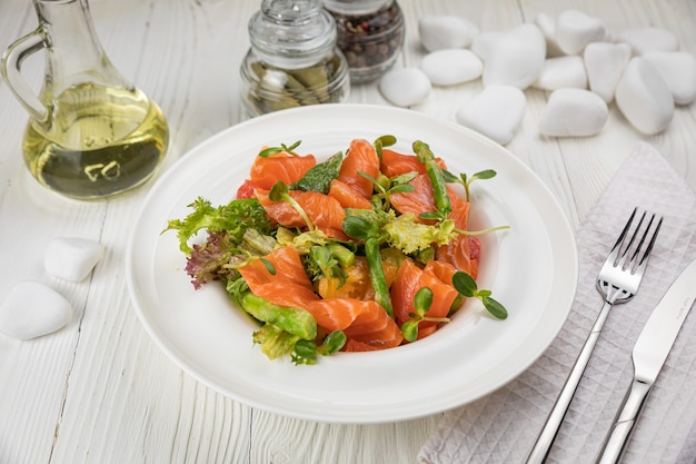 Zalm asperges en groene salade Op een witte plaat en witte tafel