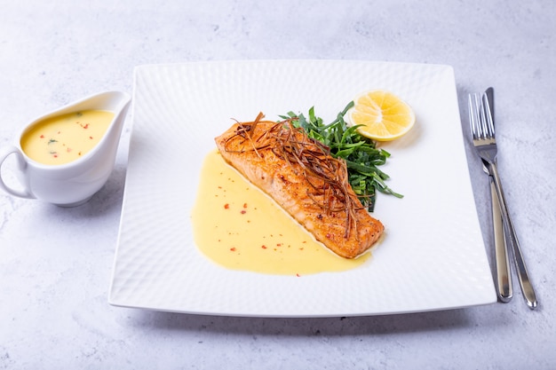 Zalm met beurre blanc saus, spinazie en citroen Gegarneerd met prei Frans gerecht