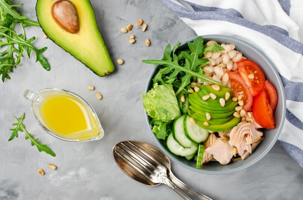 Zalm met witte bonen, tomaten, komkommers, avocado en rucola salade