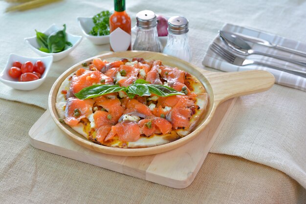 Zalm pizza op houten plaat snijplank stijl