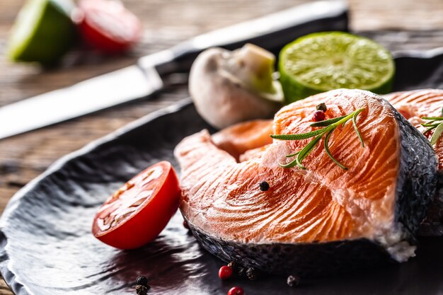 Zalm rauwe steaks rozemarijn tomaten paddestoel limoen olijfolie en specerijen - Close-up.