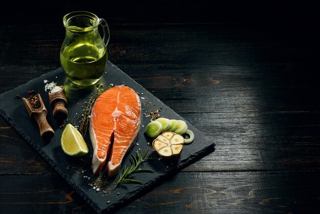 Zalm steak bereid om te frituren met ingrediënten op een donkere achtergrond