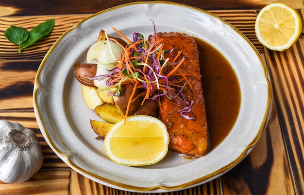 Zalm steak met aardappelen en saus op witte plaat close-up zijaanzicht