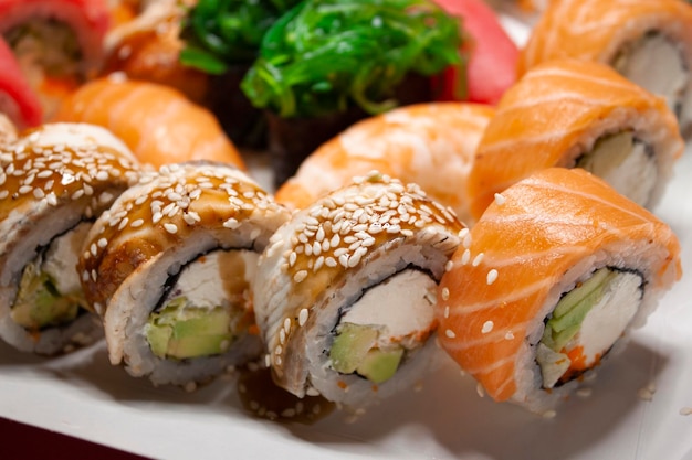 zalm tonijn chuka garnalen paling nigiri gunkan sushi rolt in witte doos op rode achtergrond