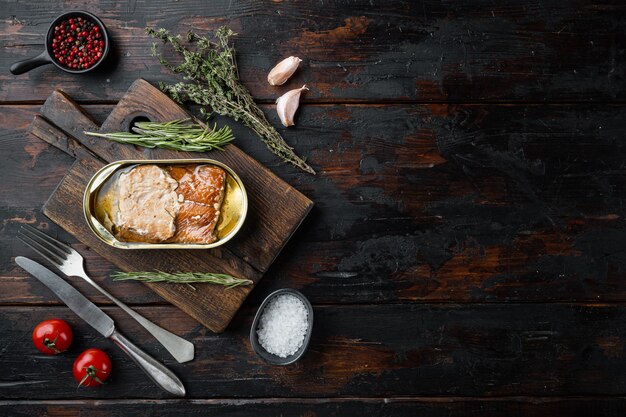 Zalm, visconserven Ingeblikte gerookte vis, op houten snijplank, op oude donkere houten tafel