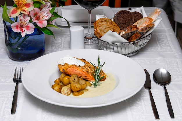 Foto zalmbrood zalmfilet bekroond met zure room bechamel saus geroosterde aardappelen voedsel