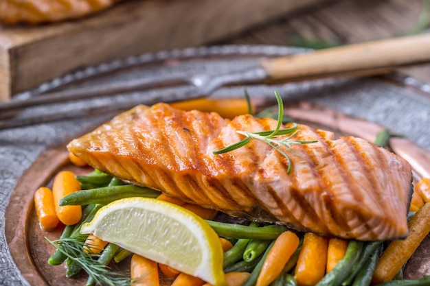 Foto zalmfilets gegrilde zalm sesamzaad kruiden decoratie op vintage pan of zwart leisteen bord vis geroosterd op een oude houten tafelstudio shot