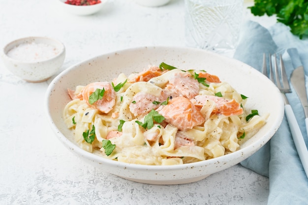 Zalmpasta, tagliatelle met vis en roomsaus. italiaans diner met zeevruchten