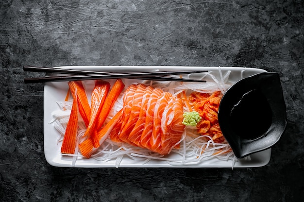 Zalmsashimi en imitatie krabstok in Japanse stijl met kimchi, wasabi.