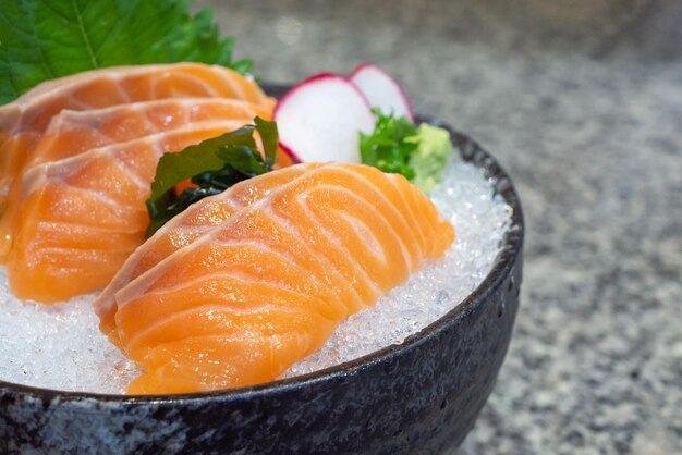 Zalmsashimi op ijs in zwart kom Japans voedsel