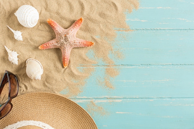 Zand en shells op de houten vloer van het blauwe, de zomerconcept
