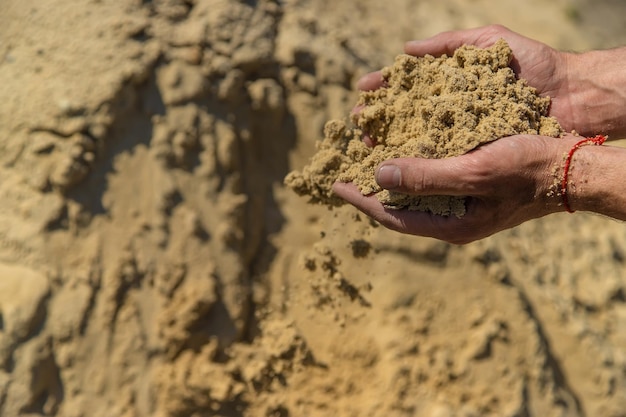 Zand in de handen van een man Selectieve focus