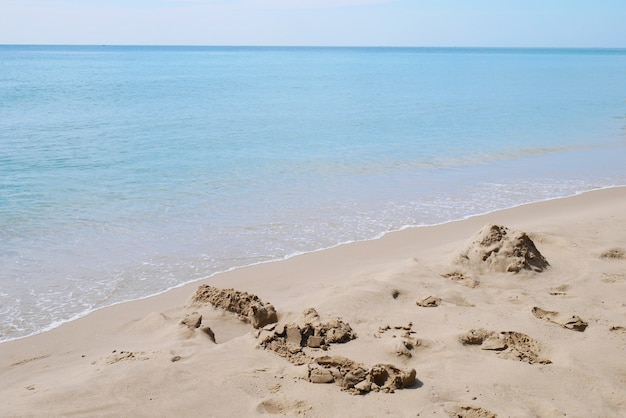 Zand met blauwe oceaan onder de blauwe hemel