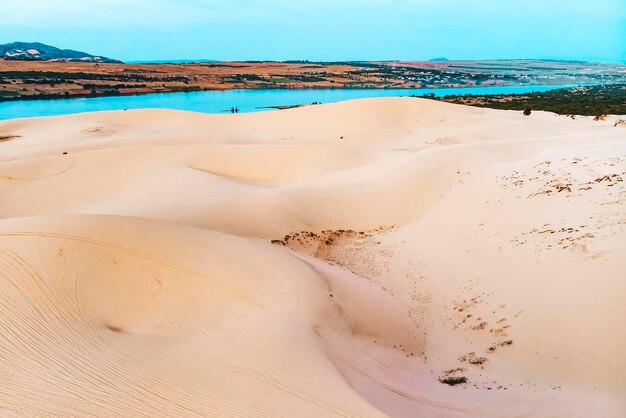 Zandduin in Mui Ne, Vietnam. Prachtig zandig woestijnlandschap. Zandduinen op de achtergrond van de rivier. Dageraad in de zandduinen van MUI ne