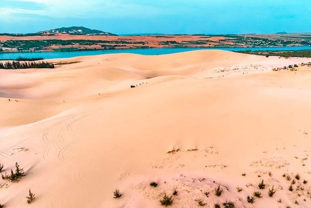 Zandduin in Mui Ne, Vietnam. Prachtig zandig woestijnlandschap. Zandduinen op de achtergrond van de rivier. Dageraad in de zandduinen van MUI ne