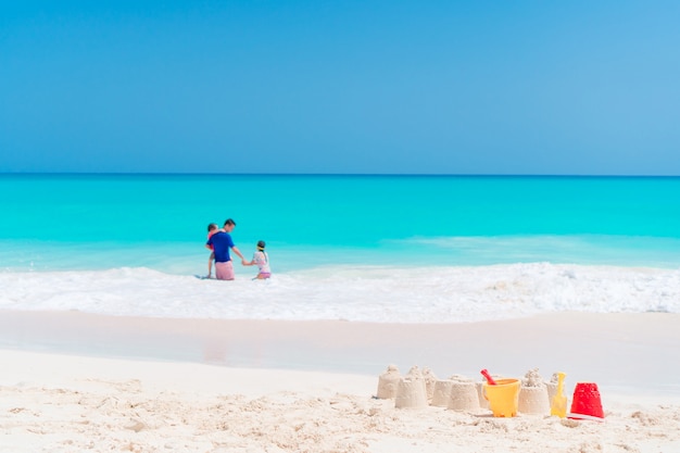 Zandkasteel op wit strand met plastic kinderspeelgoed