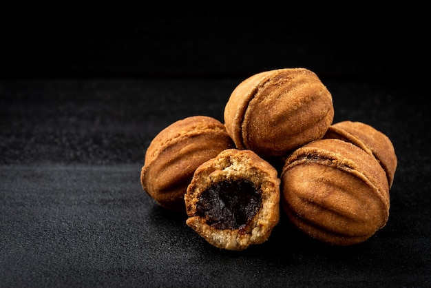 Zandkoek in vormnoot met karamel op zwarte ondergrond.