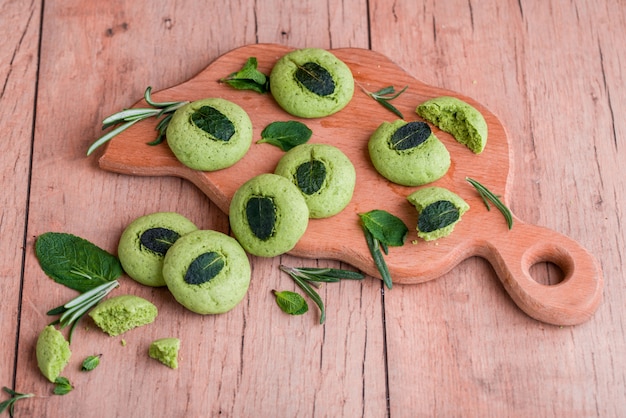 Zandkoekkoekjes met munt, geurige munt en takjes demen verdoofd op een houten tafel.