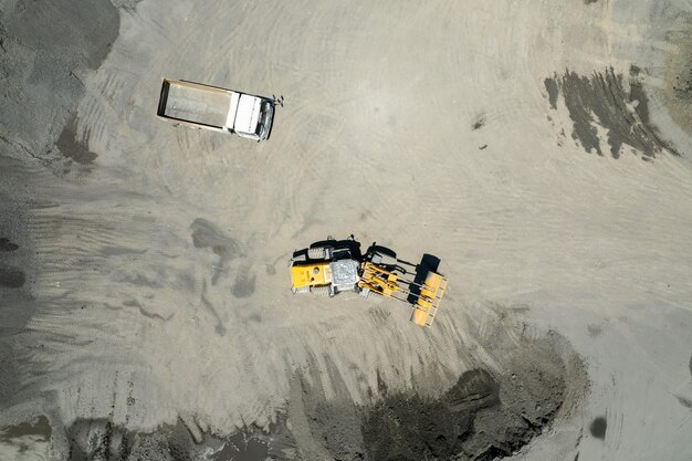 Zandladers scheppen stenen in dumptrucks