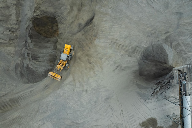 Zandladers scheppen stenen in dumptrucks