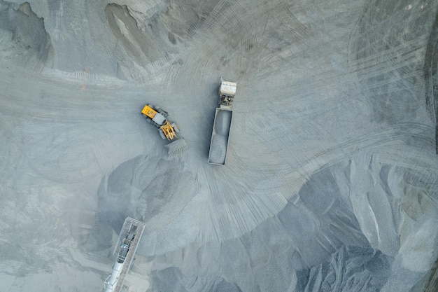 Zandladers scheppen stenen in dumptrucks