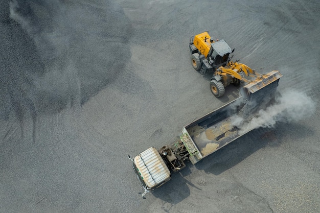 Zandladers scheppen stenen in dumptrucks