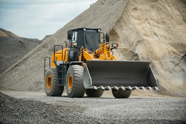 Zandladers scheppen stenen in dumptrucks