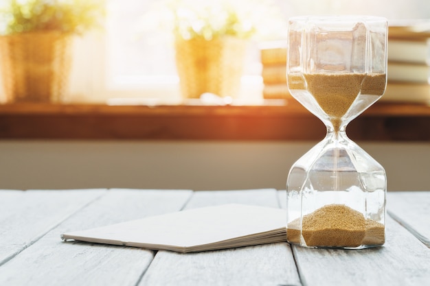 Zandloper met kalender op houten bureau