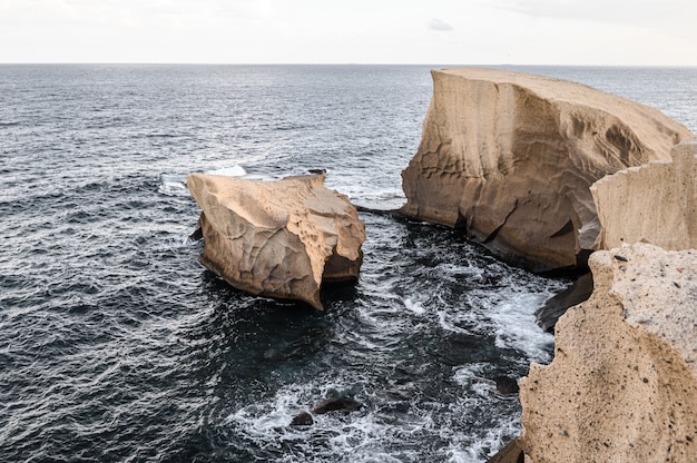 Zandsteen, creëert originele rotsen van zachte vorm. Atlantische Oceaan. San Miguel de Tajao. Tenerife, Canarische eilanden