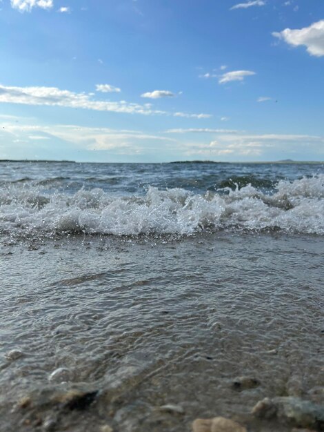 Zandstrand en blauwe zee dichtbij zachte golven lappen het zandstrand prachtige zeegolven met schuim van