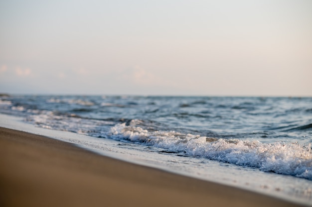 Zandstrand en zee golven bij zonsondergang. Georgia, Magneti